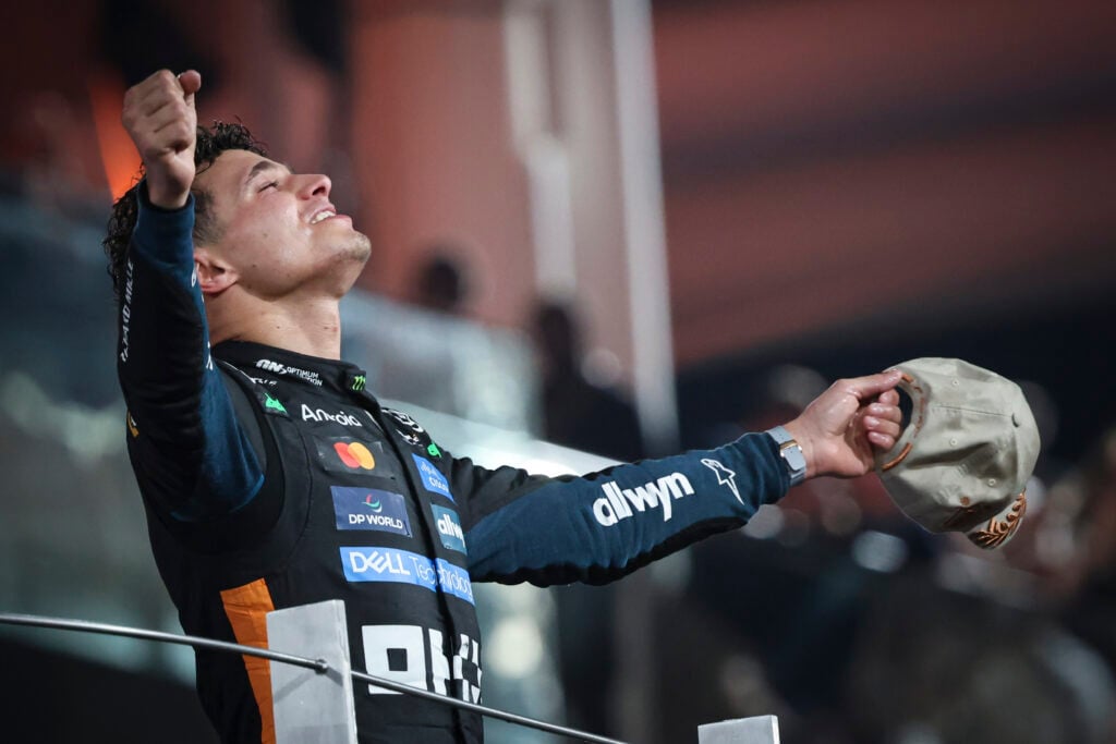 McLaren driver Lando Norris celebrating on the podium at the 2025 Formula 1 Abu Dhabi Grand Prix after winning the drivers' championship