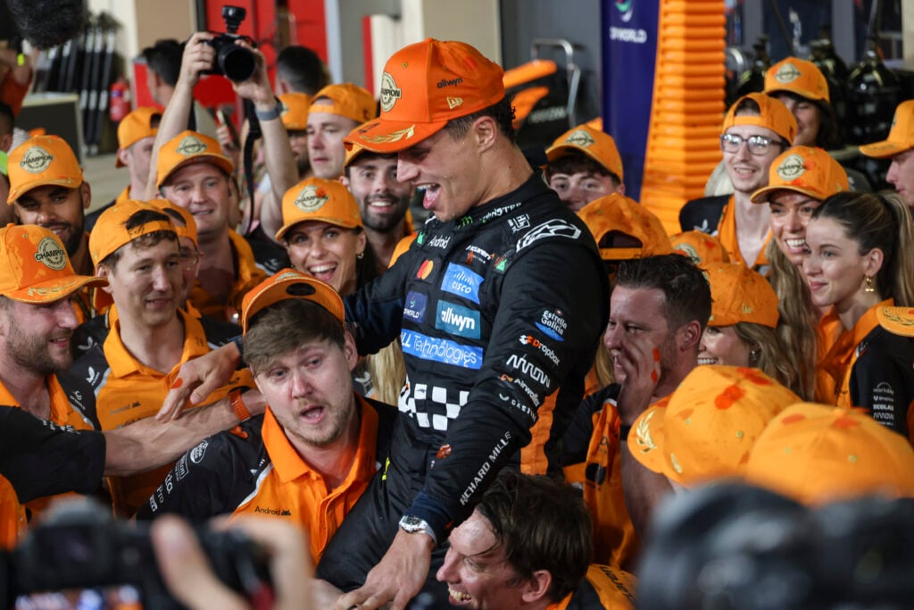 McLaren driver Lando Norris celebrating with his team after winning the 2025 Formula 1 drivers' championship in Abu Dhabi