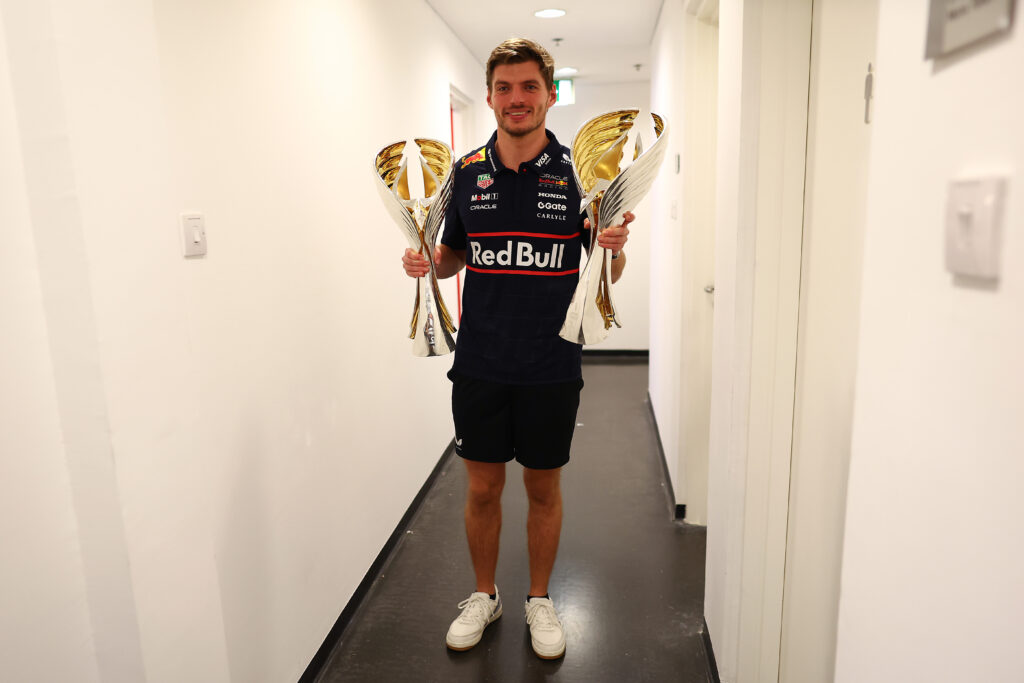 Max Verstappen holds the winning drivers' and constructors' trophies at the 2025 Abu Dhabi Grand Prix