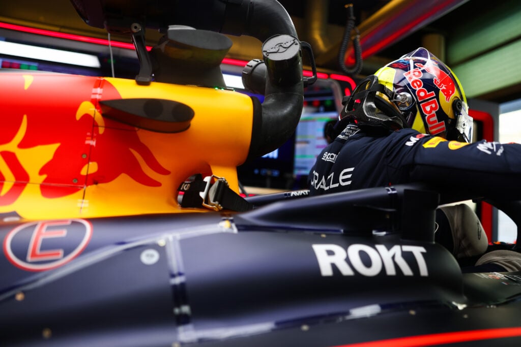 Isack Hadjar gets into his Red Bull Formula 1 car during post-season testing in Abu Dhabi in 2025