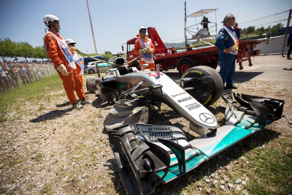 Marshals move Lewis Hamilton's car after a crash with Mercedes teammate Nico Rosberg in the 2016 F1 Spanish Grand Prix