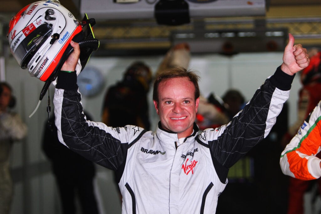 Rubens Barrichello holds up his thumb and helmet after taking pole positions for the 2009 Brazilian Grand Prix