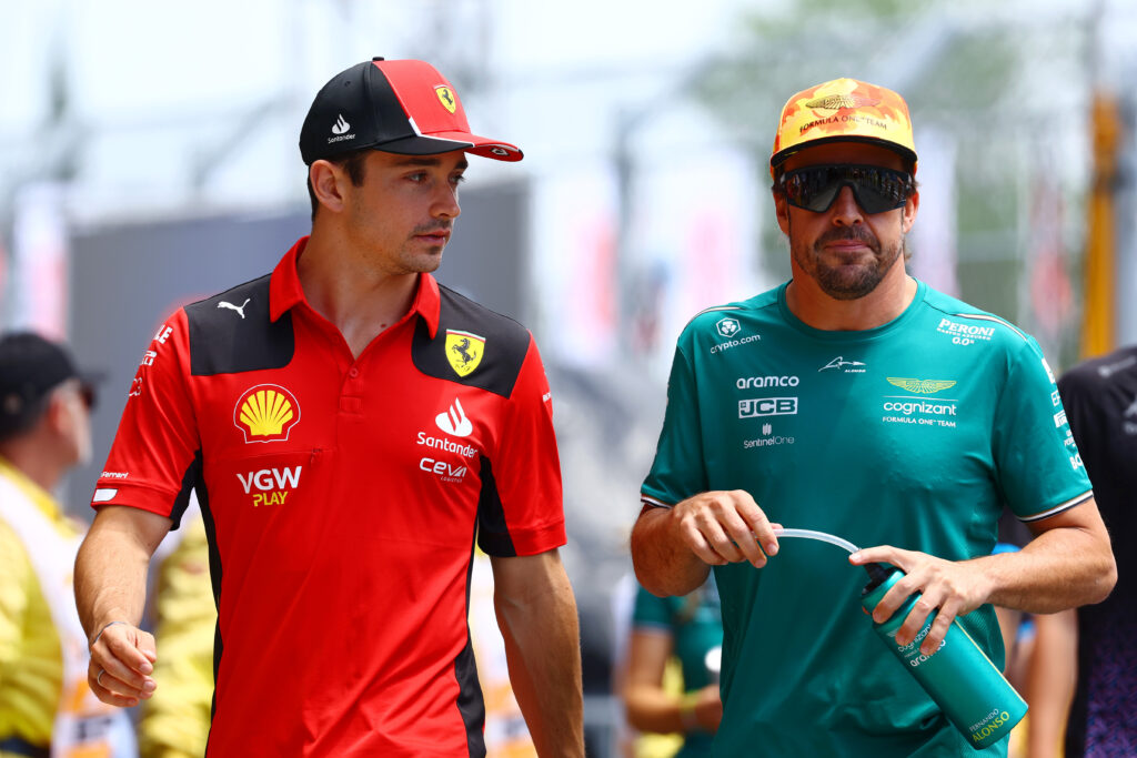 Ferrari driver Charles Leclerc and Aston Martin driver Fernando Alonso walking together in the paddock at the 2025 Formula 1 Spanish Grand Prix