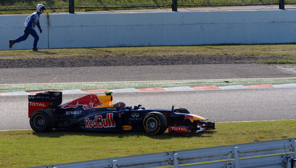 Red Bull driver Mark Webber returning to the track after being hit by Lotus driver Romain Grosjean at the 2012 Formula 1 Japanese Grand Prix
