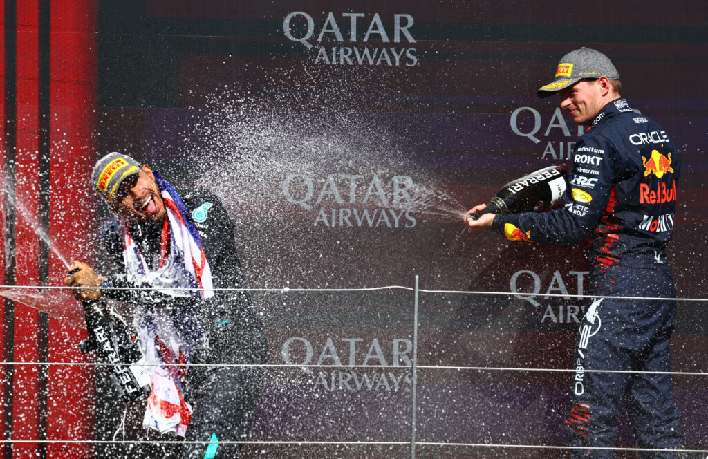 Red Bull driver Max Verstappen and Mercedes driver Lewis Hamilton celebrating on the podium at the 2024 British Grand Prix