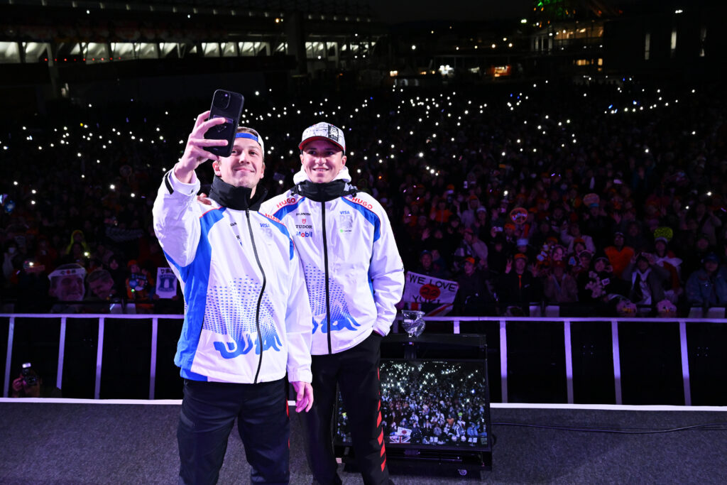 Racing Bulls drivers Liam Lawson and Isack Hadjar taking a selfie with fans at the 2025 Formula 1 Japanese Grand Prix