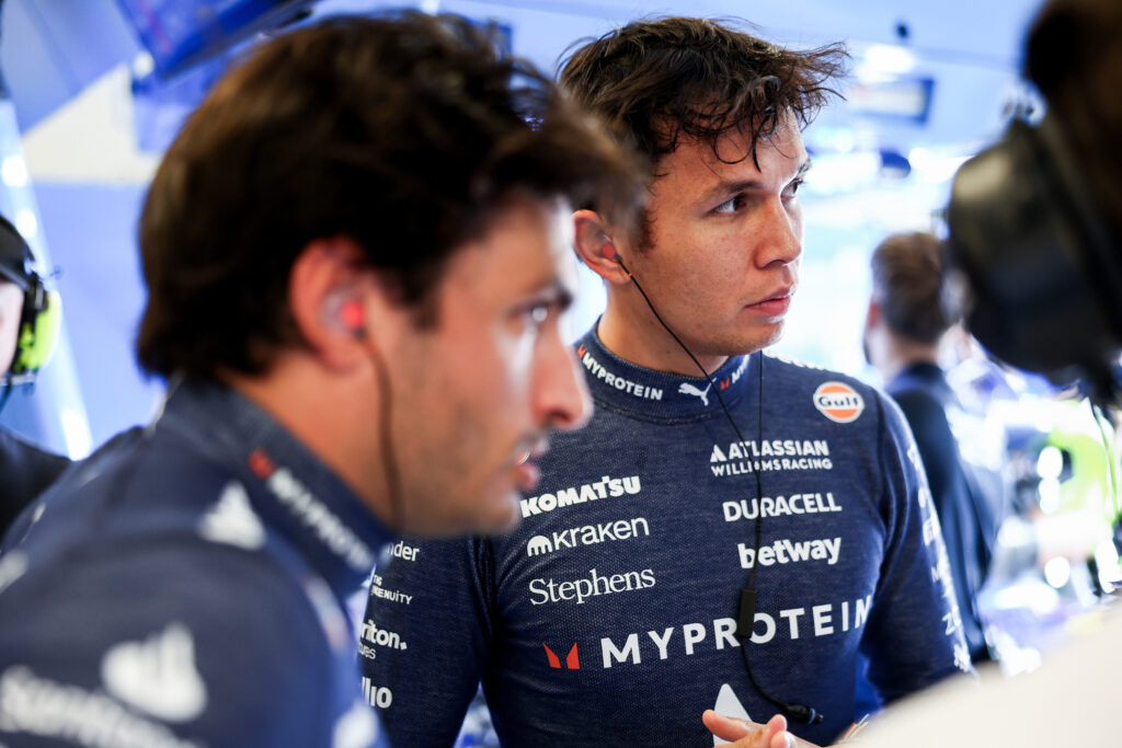 Williams drivers Alex Albon and Carlos Sainz speak in the garage during Sprint Qualifying at the 2025 F1 United States Grand Prix