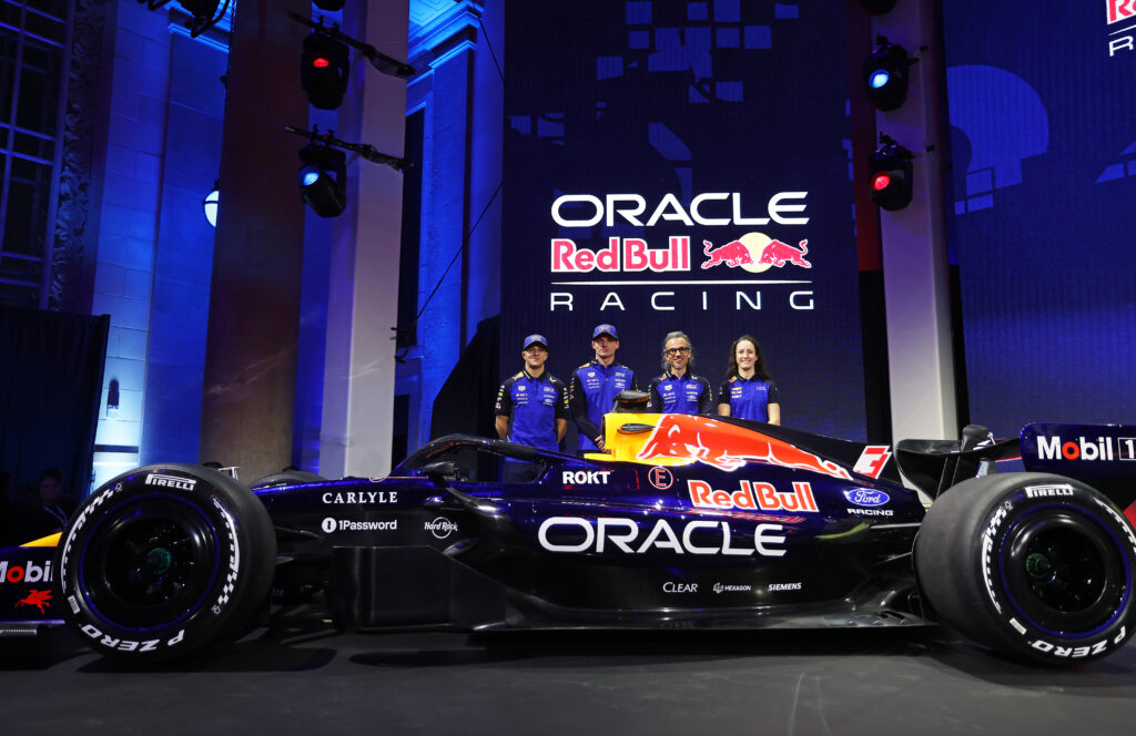 Max Verstappen, Isack Hadjar, Alisha Palmowski and Laurent Mekies standing behind Red Bull's new F1 car for the 2026 season.