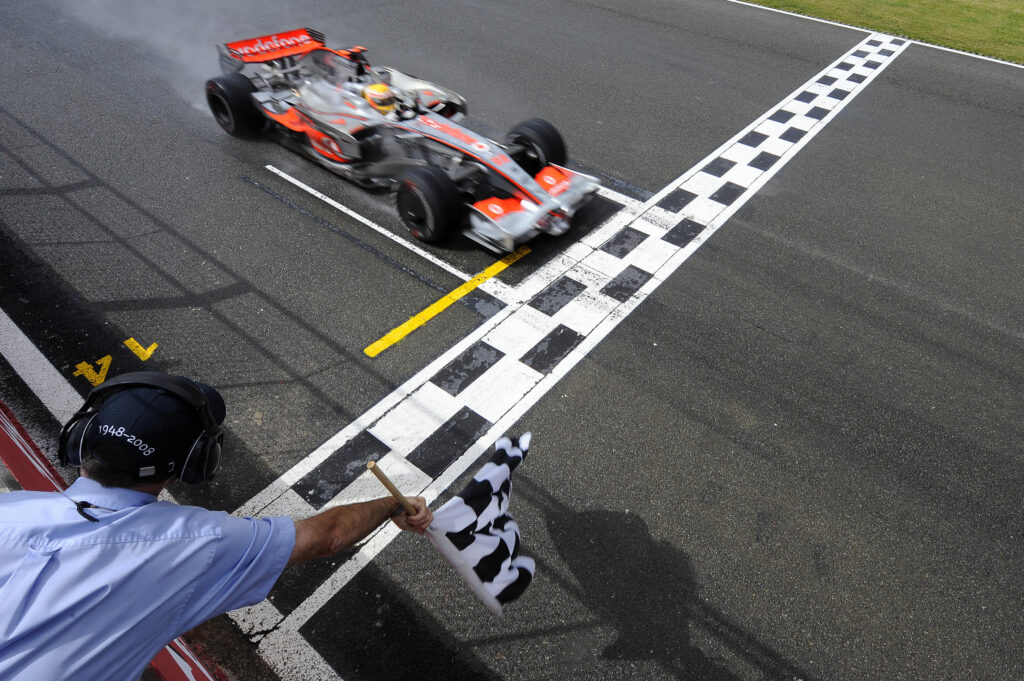 Lewis Hamilton of McLaren crossing the finish line in first place at the 2008 British Grand Prix.