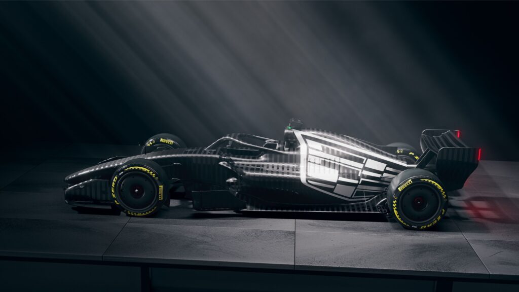 Side profile of the Cadillac Formula 1 team's Barcelona test livery. The car is a striped black and grey design with a white Cadillac logo on the engine at the back