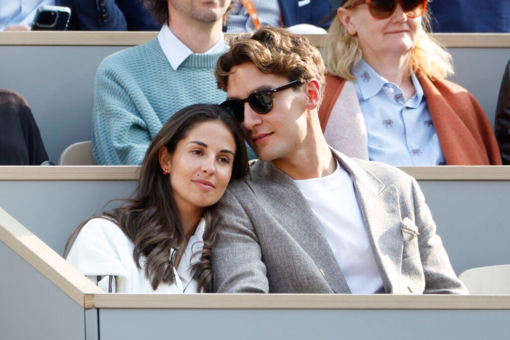 George Russell's girlfriend Carmen Montero Mundt lays her head on his shoulder during the men's final of the 2025 French Open