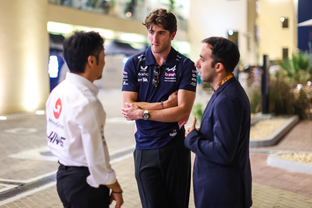 Haas team principal Ayao Komatsu speaks with Alpine reserve driver Jack Doohan in the paddock at the 2025 F1 Abu Dhabi Grand Prix