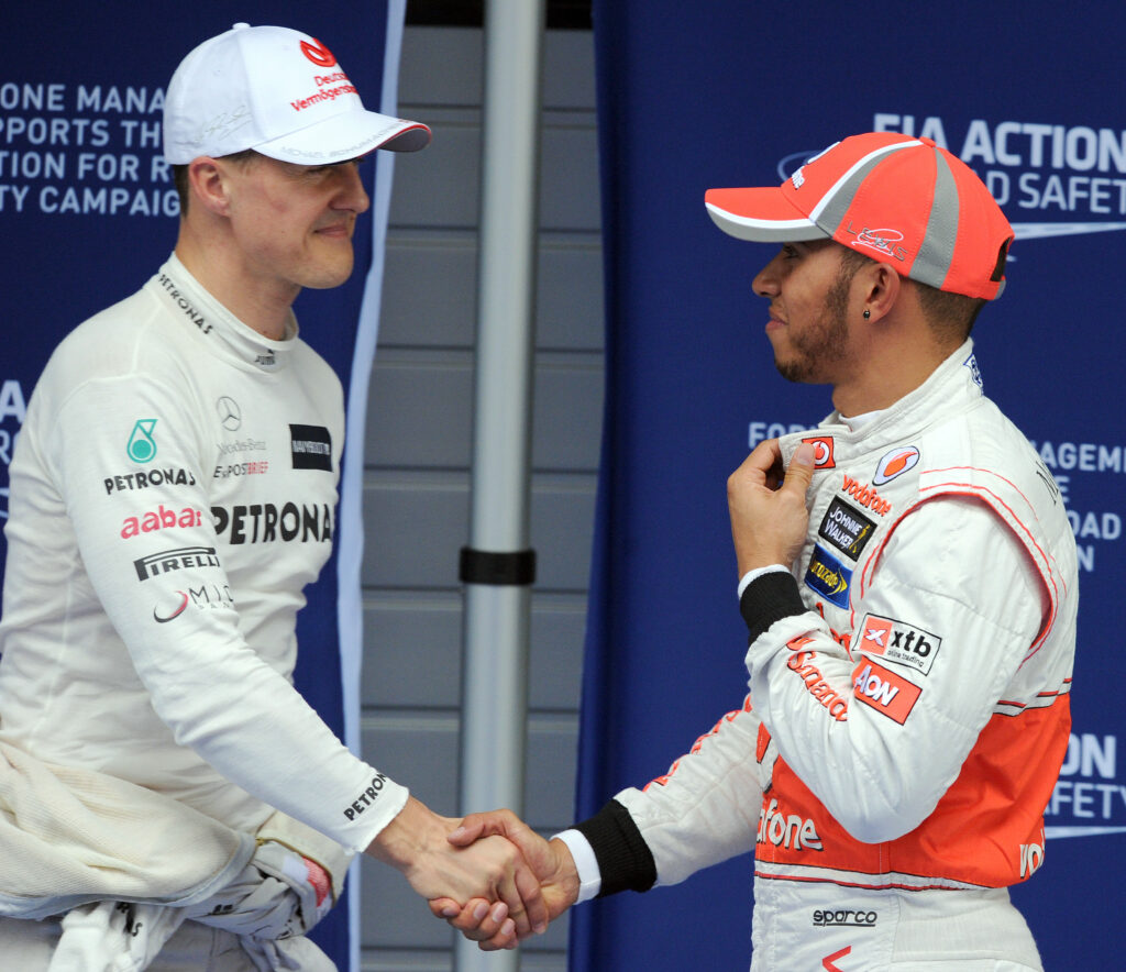 Michael Schumacher and Lewis Hamilton shaking hands at the 2012 Chinese Grand Prix