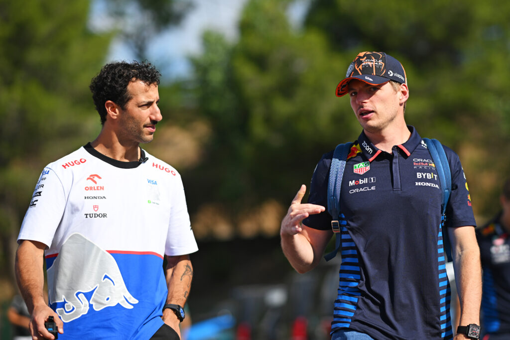 Daniel Ricciardo of Australia and Visa Cash App RB and Max Verstappen of the Netherlands and Oracle Red Bull Racing talk as they arrive in the Paddock prior to final practice ahead of the F1 Grand Prix of Spain at Circuit de Barcelona-Catalunya on June 22, 2024 in Barcelona, Spain.