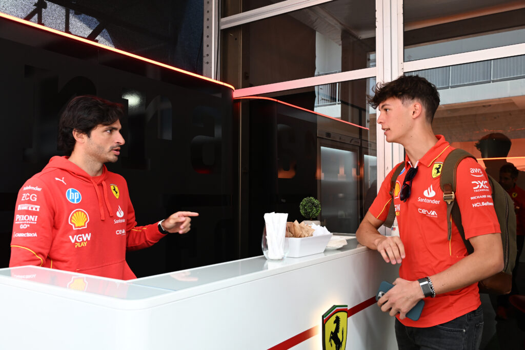 Ferrari driver Carlos Sainz speaking to reserve driver Oliver Bearman at the 2024 United States Grand Prix