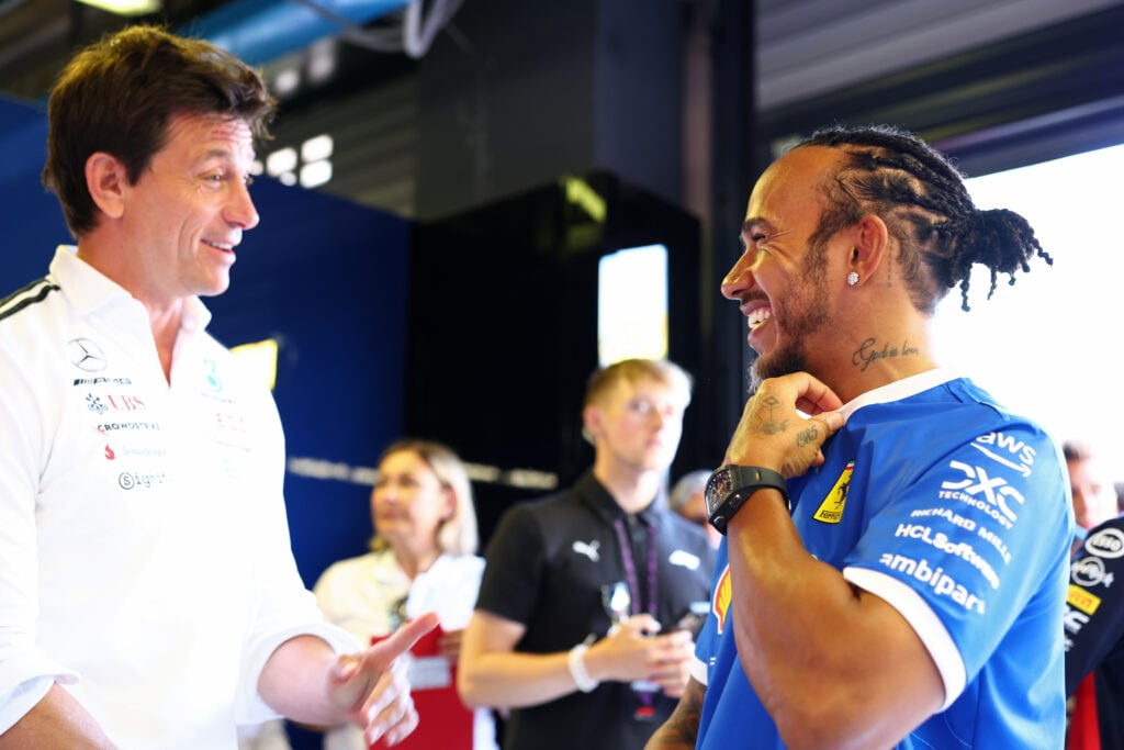 Mercedes boss Toto Wolff and Ferrari driver Lewis Hamilton speak in the FIA garage at Monza before the 2025 F1 Italian Grand Prix