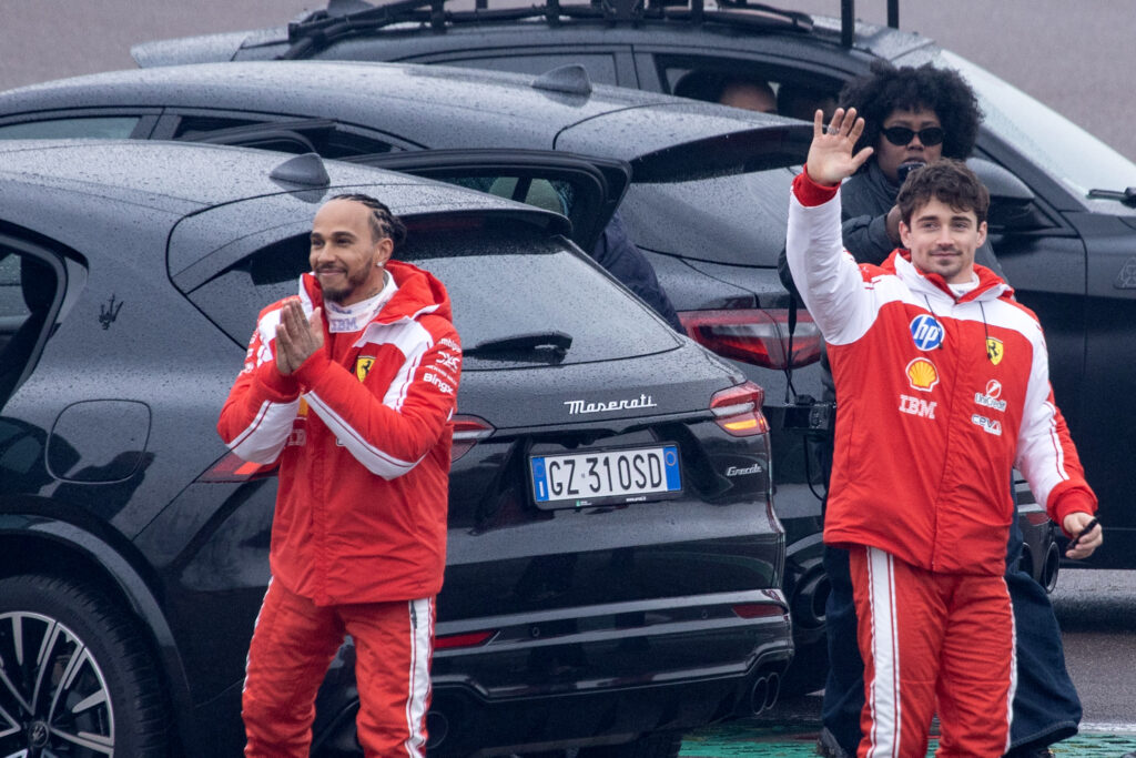Ferrari's British driver Lewis Hamilton (L) and Ferrari's Monegasque driver Charles Leclerc wave to fans after testing the new Formula 1 Ferrari SF-26 at Fiorano Circuit in Fiorano Modenese on January 23, 2026.