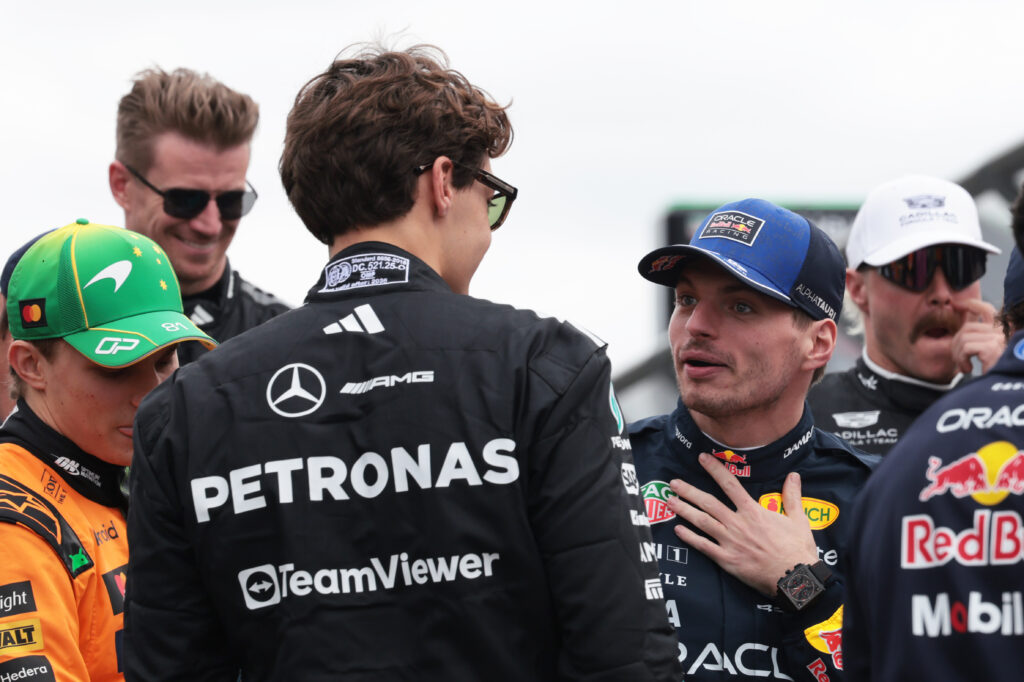Mercedes driver George Russell speaks with Red Bull's Max Verstappen before the 2026 F1 grid picture at the Australian Grand Prix