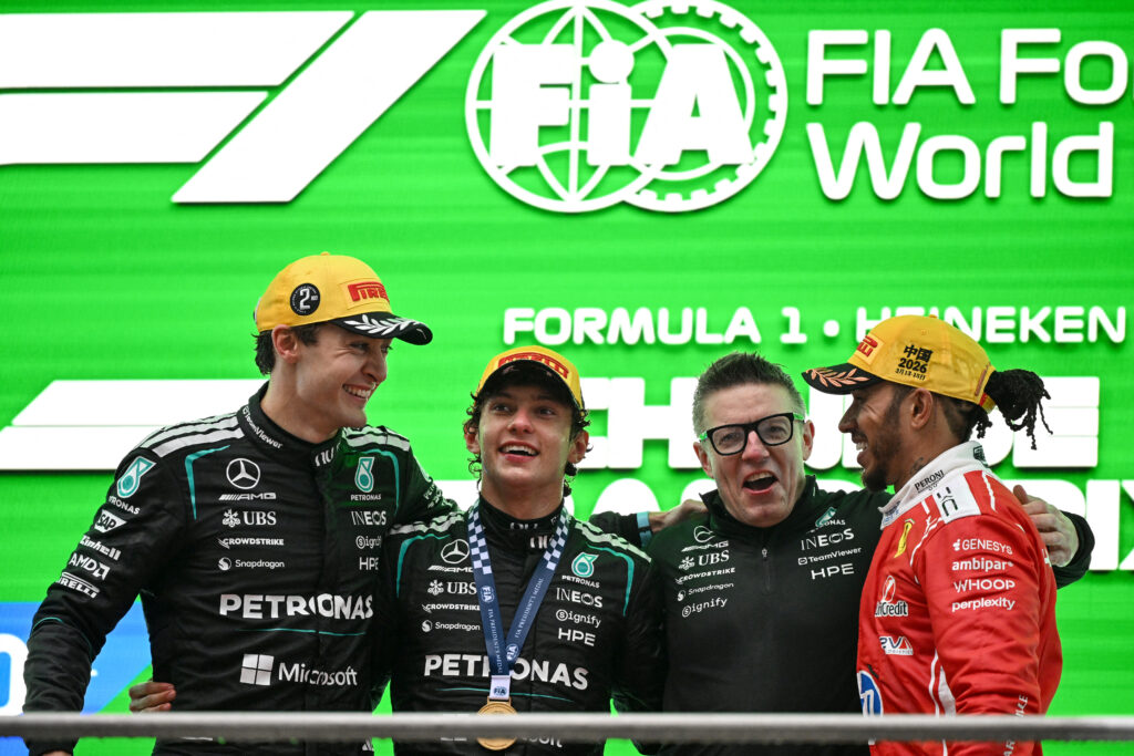 Winner Mercedes' Italian driver Kimi Antonelli (2L), second-placed Mercedes' British driver George Russell (L) and third-placed Ferrari's British driver Lewis Hamilton (R) celebrate on the podium with Mercedes' race engineer Peter Bonnington after the Formula One Chinese Grand Prix at the Shanghai International Circuit in Shanghai on March 15, 2026.