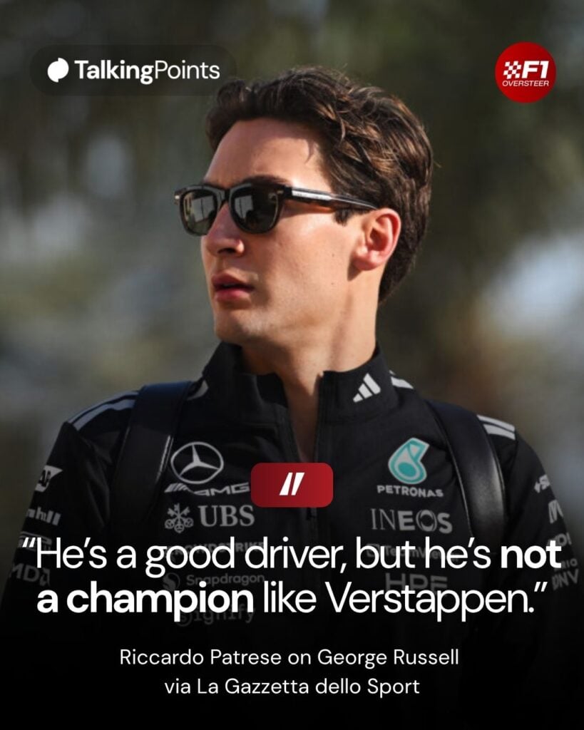 George Russell walking through the F1 paddock in Mercedes team gear and sunglasses.