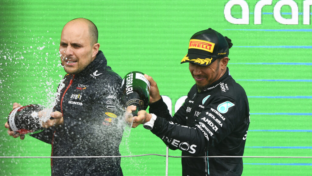 Third placed Lewis Hamilton of Great Britain and Mercedes and Red Bull Racing race engineer Gianpiero Lambiase celebrate on the podium during the F1 Grand Prix of Great Britain at Silverstone Circuit on July 09, 2023 in Northampton, England.