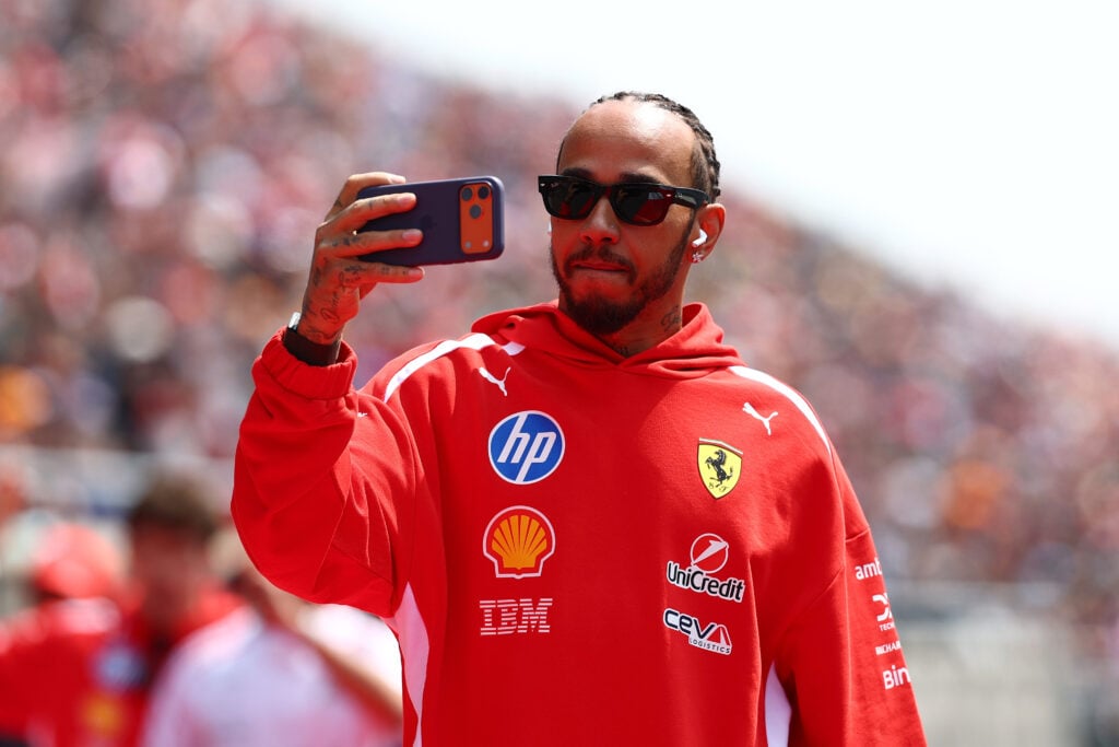 Lewis Hamilton of Ferrari uses his phone at the Japanese GP