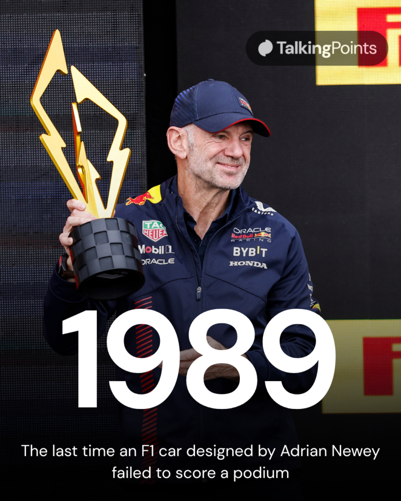 Adrian Newey holds a trophy for Red Bull on the podium