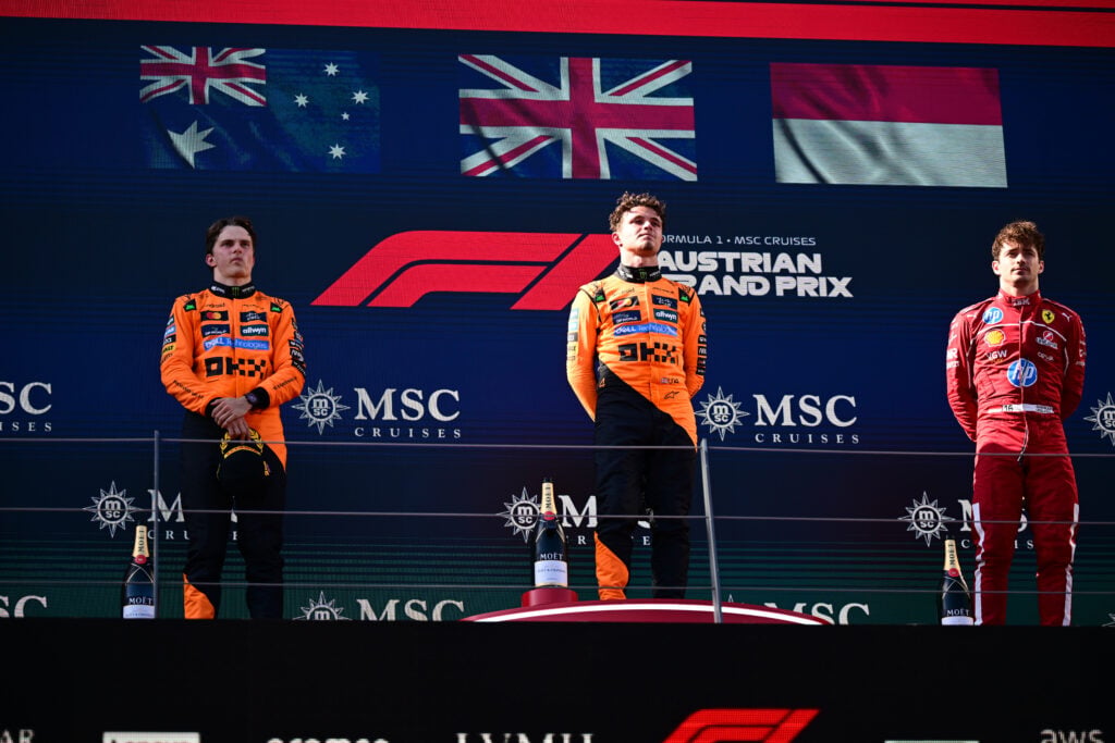 Lando Norris celebrates on the podium with Oscar Piastri and Charles Leclerc after winning the 2025 F1 Austrian Grand Prix