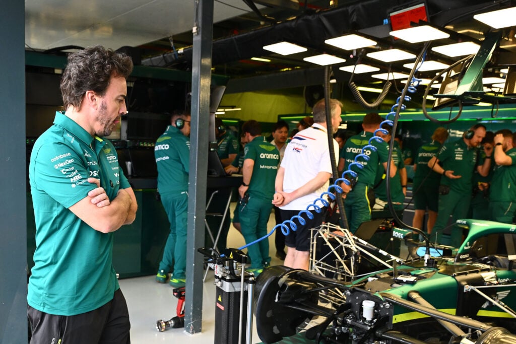 Fernando Alonso looks on as Aston Martin engineers work on his car during practice at the 2026 F1 Monaco Grand Prix