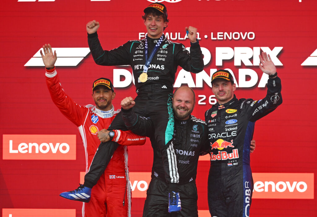 Ferrari's Lewis Hamilton and a Mercedes mechanic lift Andrea Kimi Antonelli on their shoulders after winning the 2026 F1 Canadian Grand Prix, next to Red Bull's Max Verstappen