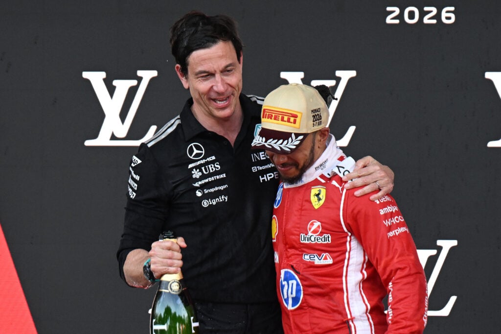 Lewis Hamilton of Ferrari on the Monaco Grand Prix podium with Toto Wolff of Mercedes