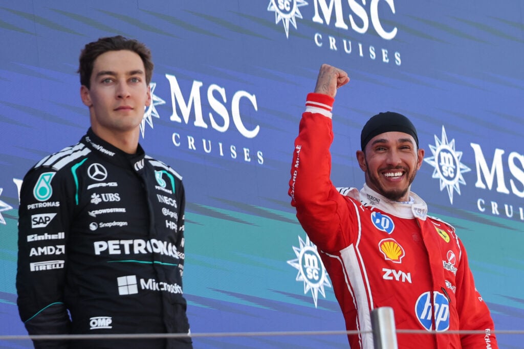 Mercedes' George Russell looks away as Ferrari driver Lewis Hamilton celebrates winning the 2026 F1 Barcelona-Catalunya Grand Prix on the podium