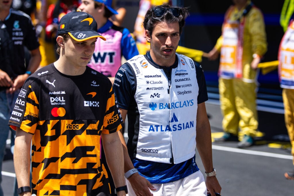 McLaren driver Oscar Piastri and Williams' Carlos Sainz walk on the grid before the 2026 F1 Barcelona-Catalunya Grand Prix