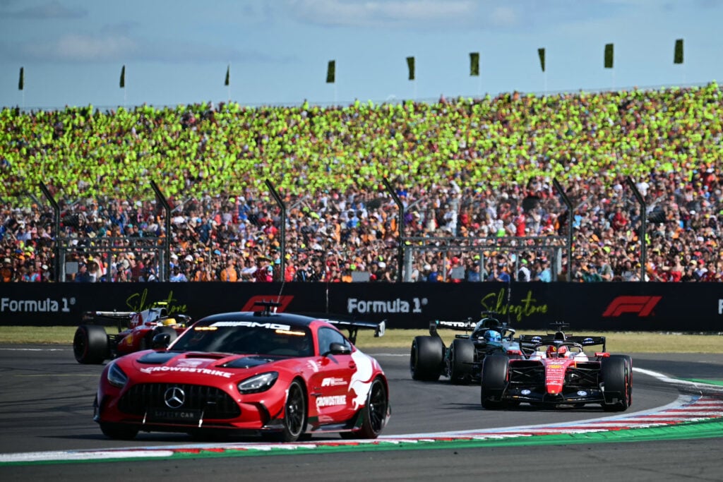 Charles Leclerc of Ferrari leads the British Grand Prix behind the safety car