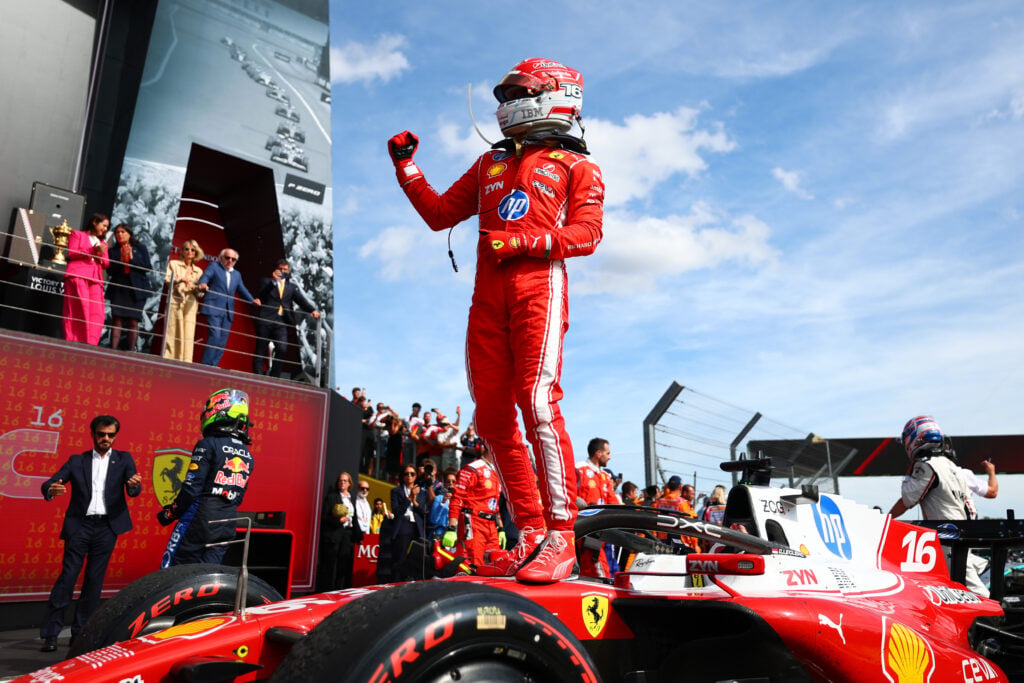 Charles Leclerc standing on top of his Ferrari SF-26 in parc ferme after winning the 2026 British Grand Prix.