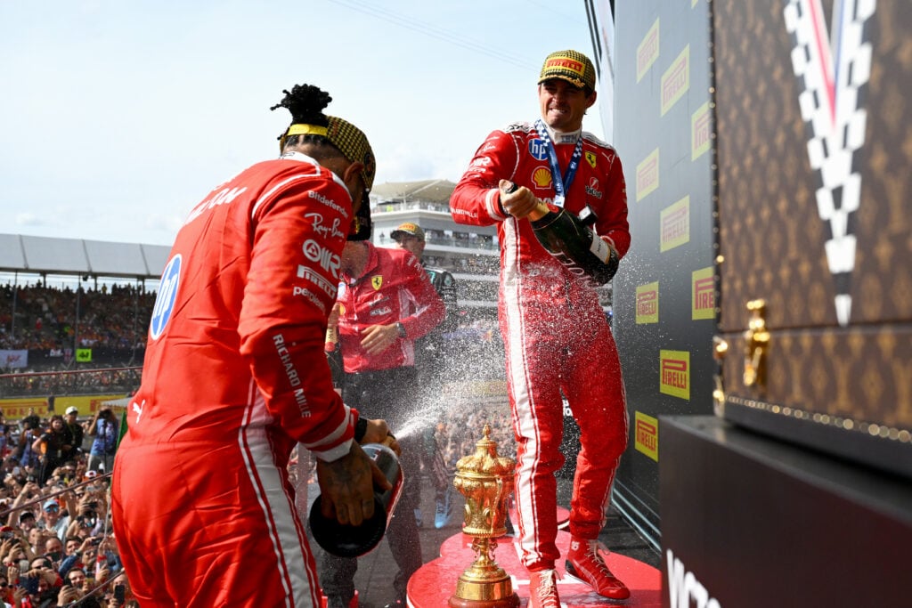 Ferrari drivers Charles Leclerc and Lewis Hamilton spray champagne on the Silverstone podium after the 2026 F1 British Grand Prix