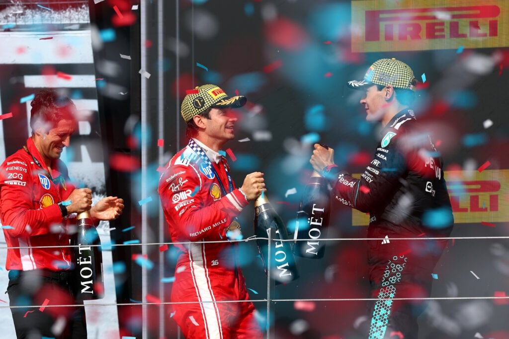 Ferrari driver Charles Leclerc celebrates on the Silverstone podium with Mercedes' George Russell after winning the 2026 F1 British Grand Prix